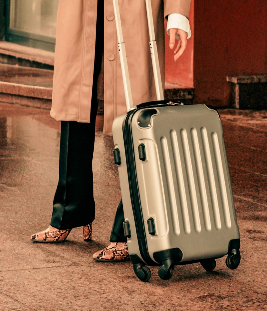 Woman rolling a carry-on suitcase