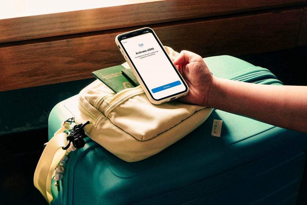 phone activating eSIM in front of suitcase