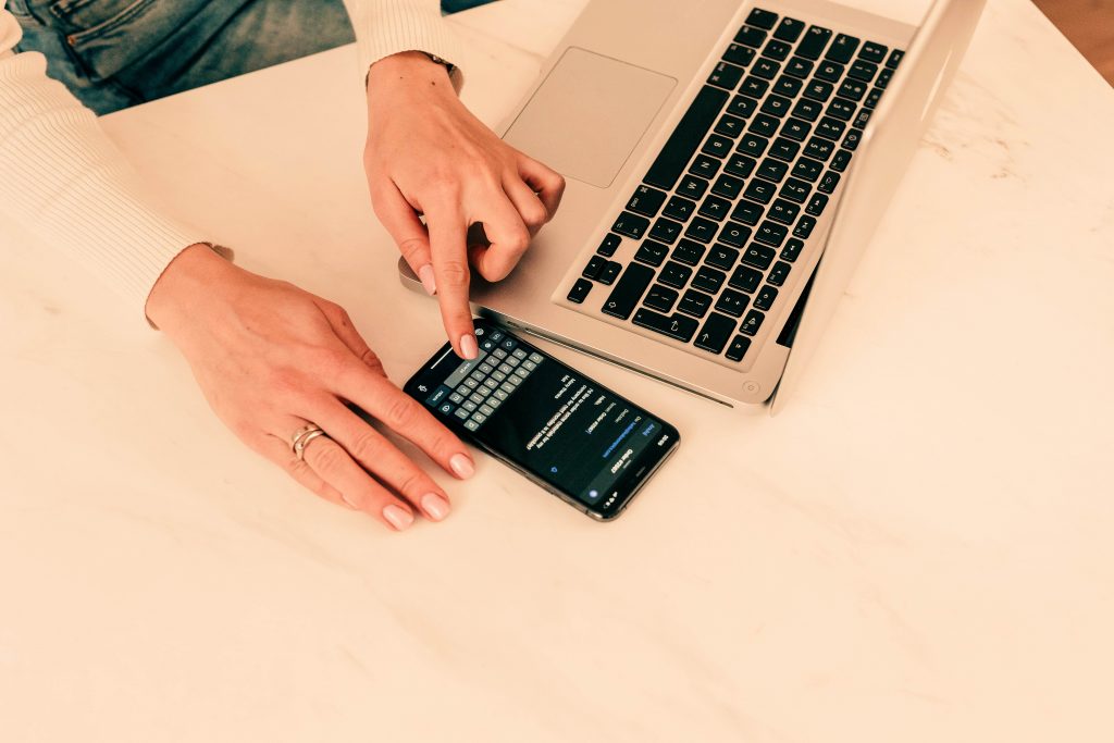 person using phone and laptop