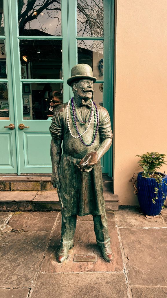 statue in new orleans with mardi gras beads