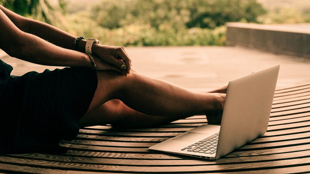 person on a laptop sitting outdoors