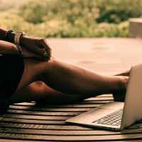 person on a laptop sitting outdoors