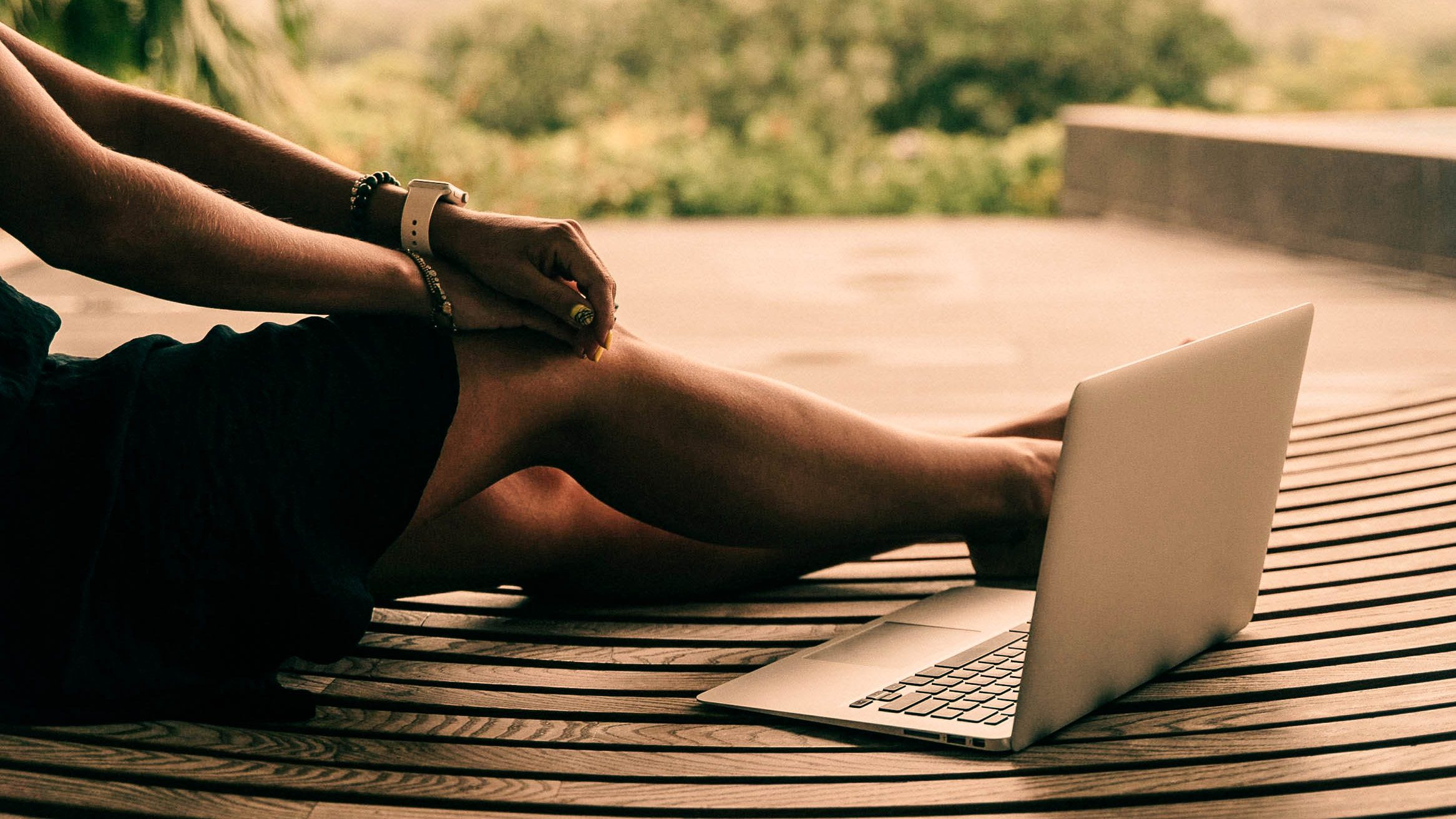 photo of a person on a laptop sitting outdoors